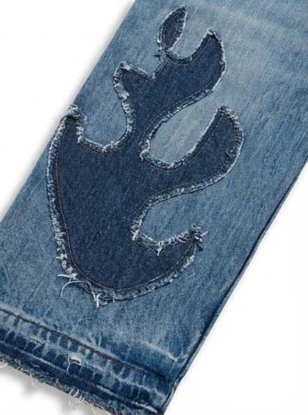 Wildgeese Close-up of blue denim jeans with a flame design on a white background
