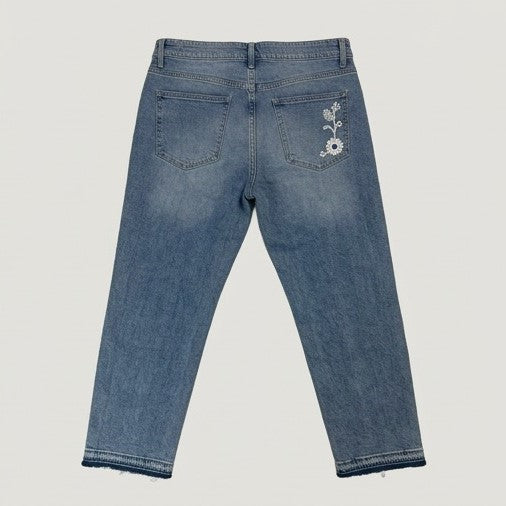 Blue jeans with floral embroidery on the back pocket against a light gray background