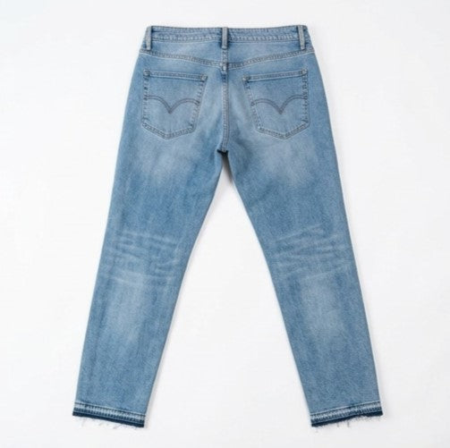 Back view of a pair of light blue jeans on a white background