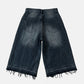 Back view of black denim shorts on a light gray background