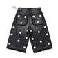 Black denim shorts with white floral patterns on a white background