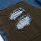 Close-up of a brown fabric patch with blue frayed edges on a denim background
