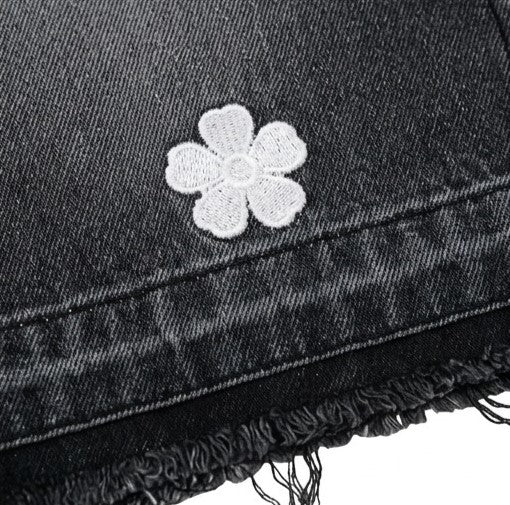 Black denim jacket with a white embroidered flower on a white background