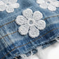 Close-up of denim fabric with white floral embroidery