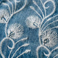Close-up of blue denim fabric with white floral embroidery