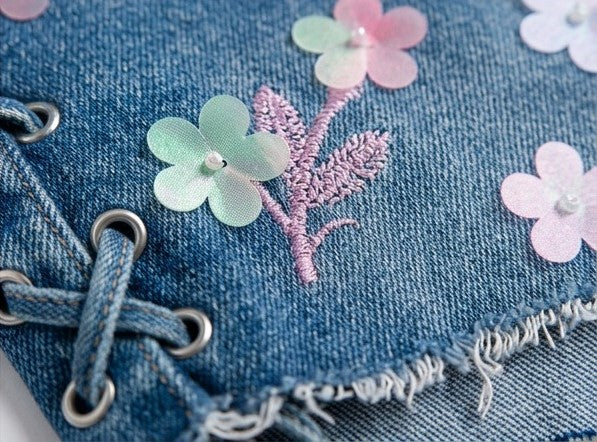 Blue denim fabric with floral embroidery and pink stitching