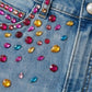 Close-up of a denim jacket with colorful gemstones
