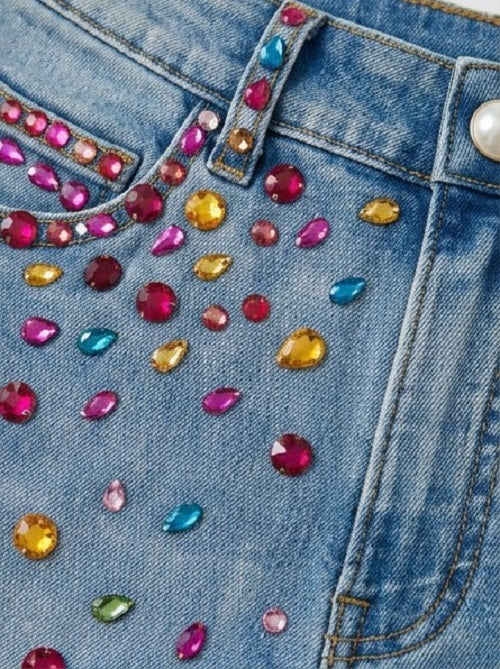 Close-up of a denim jacket with colorful gemstones
