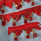 Red beaded lace trim with gold accents on a denim background