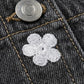 Close-up of a button and embroidered flower on denim fabric