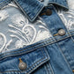 Close-up of a denim jacket with white floral embroidery