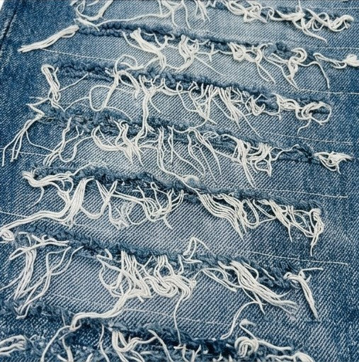 Close-up of distressed denim fabric with frayed edges.