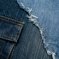 Close-up of blue denim fabric with frayed edge