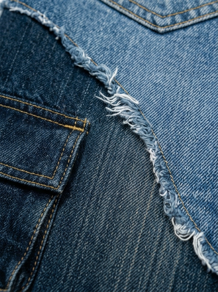 Close-up of blue denim fabric with frayed edge