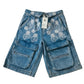 Blue denim shorts with floral embroidery on a white background