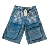 Blue denim shorts with floral embroidery on a white background