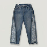 Blue jeans with floral lace panels on a light gray background
