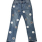 Blue jeans with floral embellishments on a white background