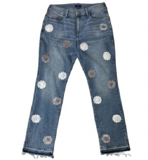 Blue jeans with floral embellishments on a white background