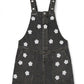 Black denim pinafore dress with white floral patterns on a white background