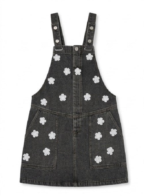 Black denim pinafore dress with white floral patterns on a white background