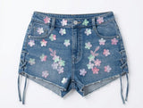 Denim shorts with floral patterns on a white background