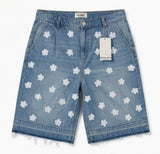 Denim shorts with white floral patterns on a white background