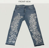 Blue jeans with floral embroidery on a white background
