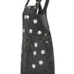 Black denim pinafore dress with white floral patterns on a white background