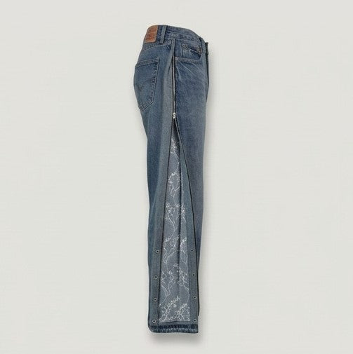 Blue jeans with a zipper detail on a light gray background