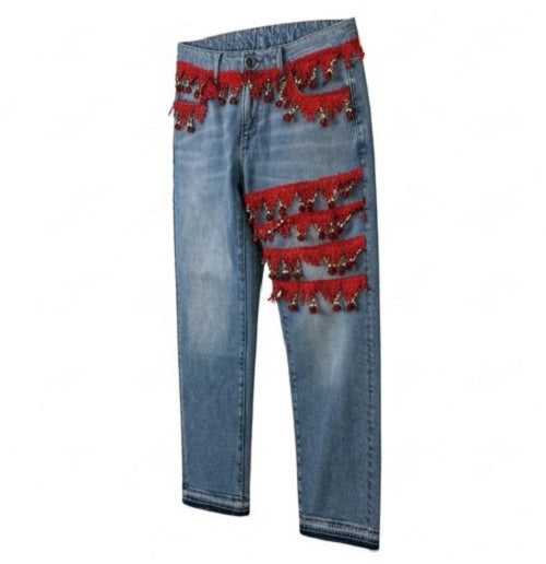 Blue jeans with red fringe and beads on a white background