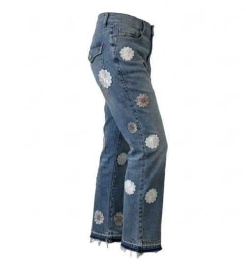Blue jeans with floral patches on a white background