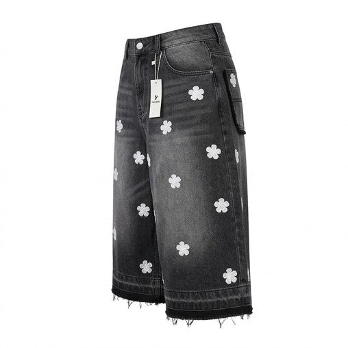 Black denim skirt with white floral patterns on a white background
