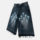 Black denim shorts with blue cross patterns on a white background