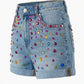 Denim shorts with colorful gemstones on a white background