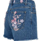 Blue denim skirt with floral embroidery on a white background